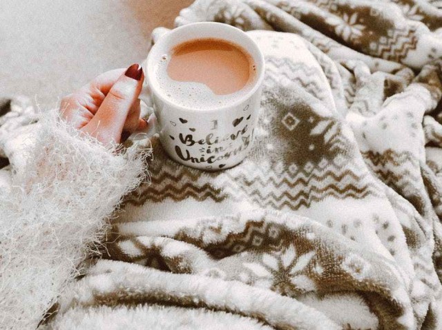 person holding coffee filled mug