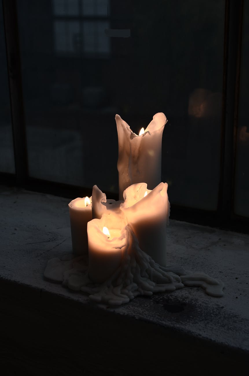 burning candles with melted wax at night