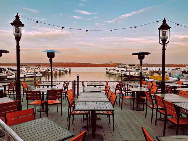 cafe terrace against port at seaside during sunset